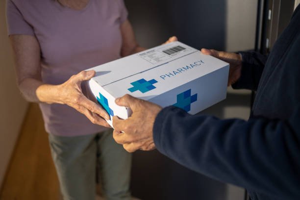 senior woman received medicine package from delivery person.